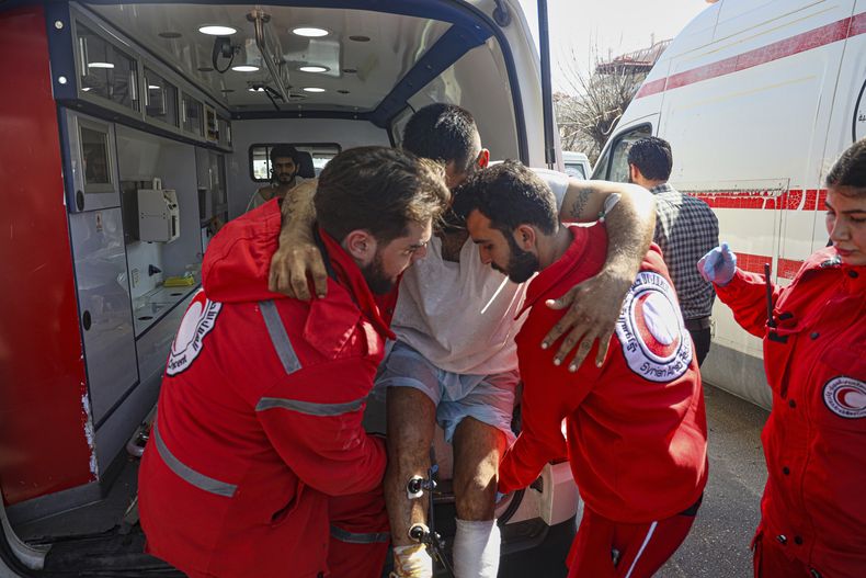 ARCHIVO - Paramédicos de la Media Luna Roja trasladan a un hombre herido fuera de la base aérea rusa en Hmeimim, cerca de Latakia, en la región costera de Siria, el 11 de marzo de 2025, cuando evacuan a miembros heridos de la secta alauita que se han refugiado allí tras los recientes actos de violencia y asesinatos por venganza. (AP Foto/Omar Albam, archivo)