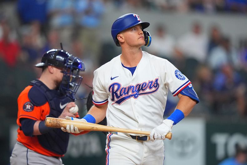 Josh Jung, de los Rangers de Texas (derecha), se dirige al dugout tras poncharse durante la octava entrada de un partido de béisbol contra los Astros de Houston, el sábado 11 de julio de 2026, en Arlington, Texas. (Foto AP/LM Otero)