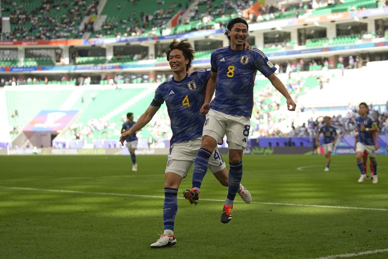 Takumi Minamino (derecha) celebra tras anotar el primer gol en la victoria 4-2 ante Vietnam en la Copa de Asia, el domingo 14 de enero de 2023, en Doha, Qatar. (AP Foto/Thanassis Stavrakis)