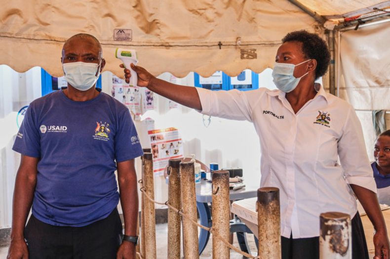 Una trabajadora de la salud revisa la temperatura de una persona en una clínica temporal en el cruce fronterizo de Mpondwe que conecta Uganda y la República Democrática del Congo, el 4 de junio de 2026. (Foto AP/Hajarah Nalwadda, Archivo)