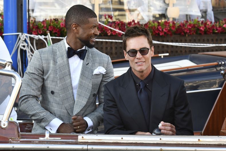 Usher, izquierda, y Tom Brady salen de un hotel previo a la boda de Jeff Bezos y Lauren Sanchez, en Venecia, Italia, el viernes 27 de junio de 2025. (Foto AP/Luigi Costantini)
