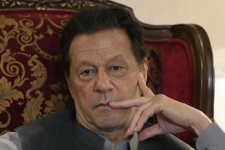 ARCHIVO - El ex primer ministro de Pakistán Imran Khan escucha a un periodista durante una conversación con reporteros sobre la situación política actual y los casos en su contra en su residencia de Lahore, Pakistán, el 3 de agosto de 2023. (AP Foto/K.M. Chaudary, Archivo)