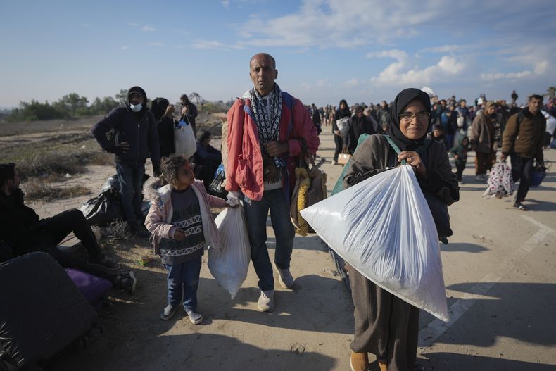 Neman Abu Jarad y su esposa Majida caminan con sus hijos mientras miles de palestinos desplazados regresan a sus hogares en el norte de la Franja de Gaza, el 27 de enero de 2025. (AP Foto/Abdel Kareem Hana)