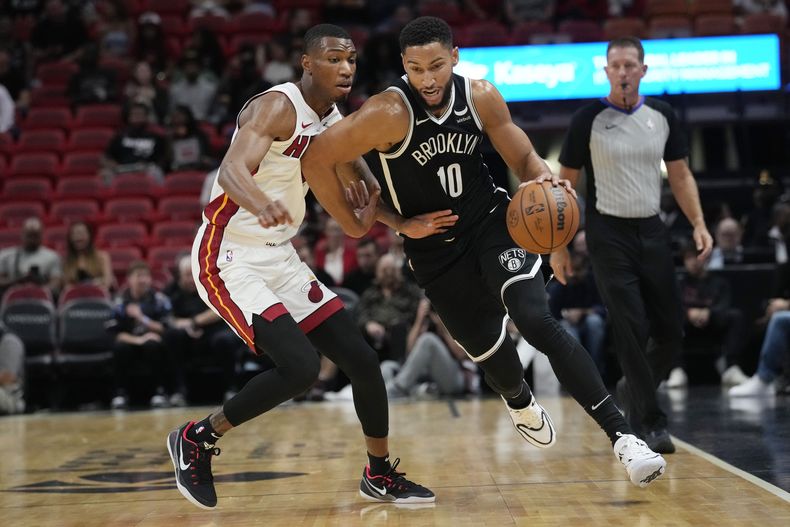 El base de los Nets de Brooklyn Ben Simmons maneja el balón frente al alero del Heat de Miami Jamal Cain en un duelo de pretemporada el miércoles 18 de octubre del 2023. (AP Foto/Marta Lavandier)