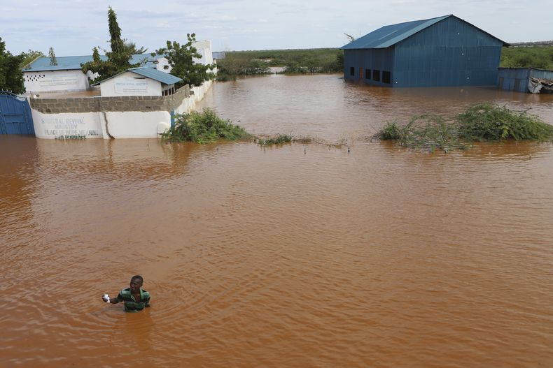 Un hombre camina por una zona sumergida, después de que el río Tana se desbordó por las fuertes lluvias en Mororo, noreste de Kenia, el 28 de abril de 2024. (Foto AP/Andrew Kasuku)