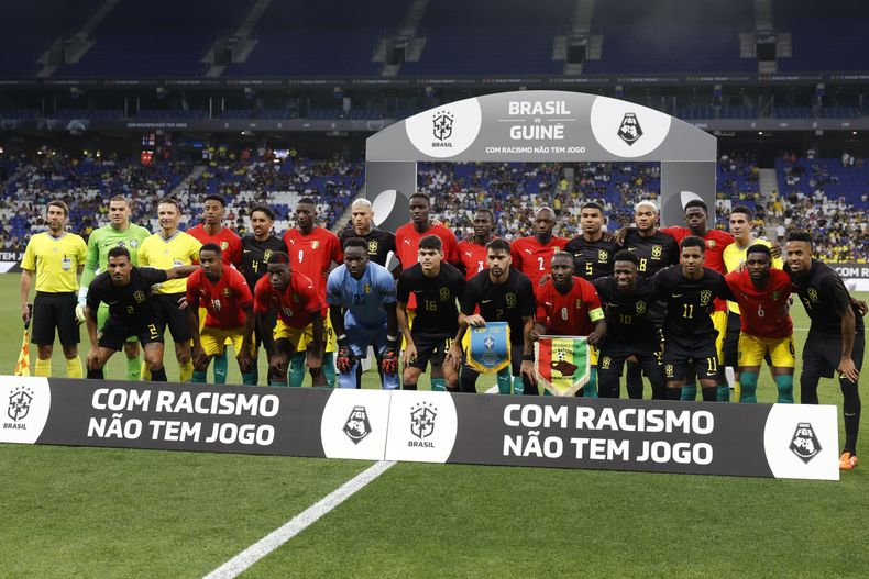 Los jugadores de Brasil y Guinea posan con un mensaje contra el racismo previo a un partido amistoso, el sábado 17 de junio de 2023, en Barcelona. (AP Foto/Joan Monfort)