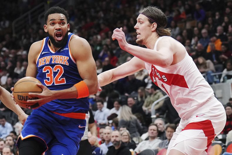 Karl-Anthony Towns, de los Knicks de Nueva York, avanza frente a Kelly Olynyk, de los Raptors de Toronto, el martes 4 de febrero de 2025 (Nathan Denette/The Canadian Press via AP)