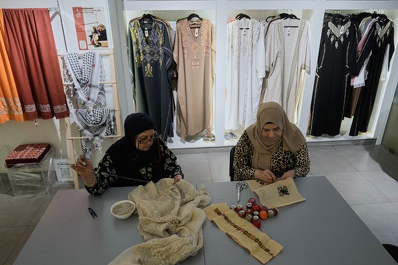 Las costureras palestinas Rula Barakeh, a la derecha, y Samira Nasser trabajan en piezas bordadas a mano en el taller de la Asociación Inaash en Beirut, el martes 19 de 2026. (AP Foto/Bilal Hussein)