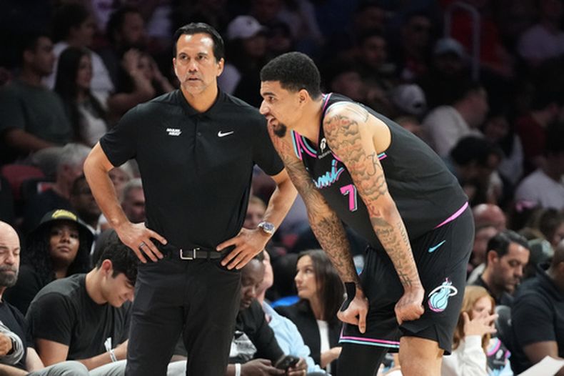 Erik Spoelstra, entrenador del Heat de Miami, escucha al centro Kelel Ware (7) durante el segundo tiempo del partido contra los Wizards de Washington, el domingo 4 de abril de 2026, en Miami. (AP Foto/Marta Lavandier)