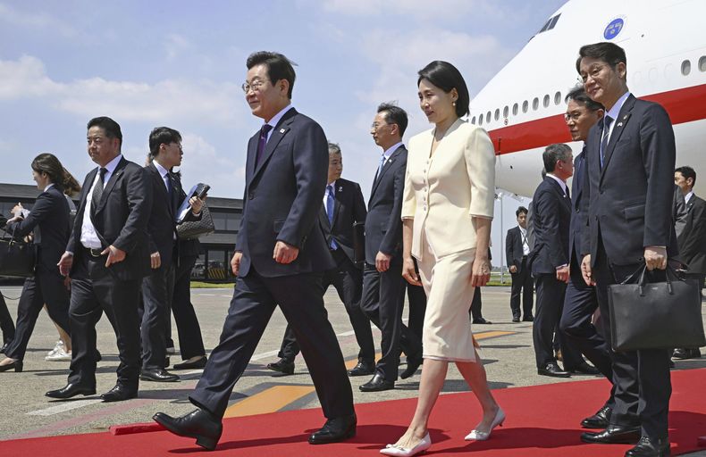 El presidente de Corea del Sur, Lee Jae Myung (centro, izquierda), y su esposa, Kim Hea Kyung (centro), a su llegada al aeropuerto de Haneda, en Tokio, Japón, el 23 de agosto de 2025. (Kyodo News vía AP)