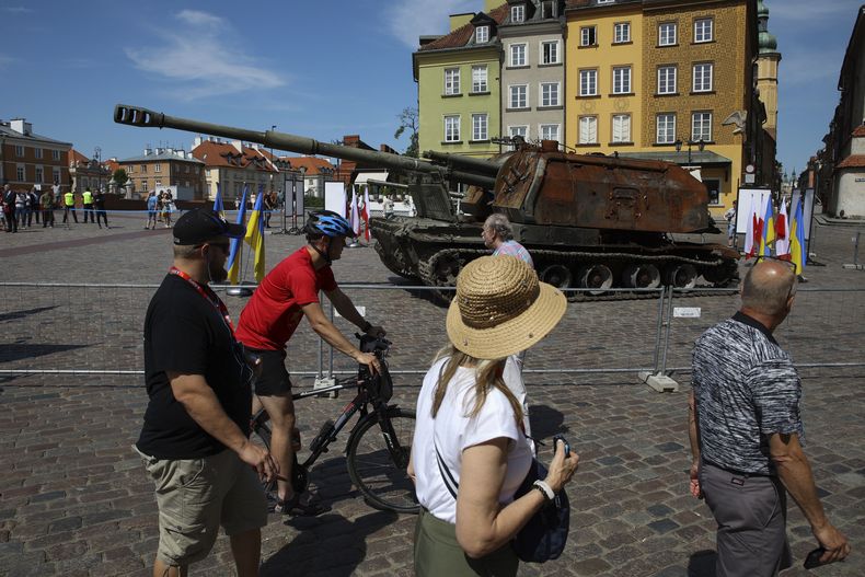 ARCHIVO – Varias personas visitan una exposición al aire libre de tanques y vehículos armados rusos dañados y desgastados en la Plaza del Castillo, en Varsovia, Polonia, el 27 de junio de 2022. (AP Foto/Michal Dyjuk, Archivo)