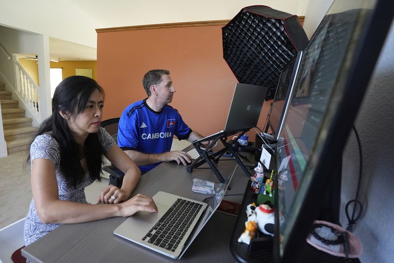 Jason Breck y Daravy Khiev trabajan en su casa, el miércoles 23 de julio de 2025, en Fishers, Indiana. (AP Foto/Darron Cummings)