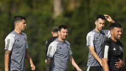 El delantero de Inter Miami Luis Suárez, a la izquierda, camina con el delantero Lionel Messi, centro, y el defensa Sergio Busquets, segundo a la derecha, durante una sesión de entrenamiento de fútbol de la MLS, el sábado 13 de enero de 2024, en Fort Lauderdale, Florida. (AP Foto/Rebecca Blackwell)