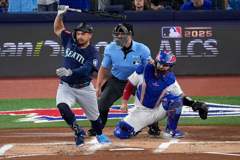 Josh Naylor, de los Marineros de Seattle, sigue el swing en un hit productor de carrera contra Shane Bieber (57), lanzador de los Azulejos de Toronto, durante la primera entrada en el Juego 7 de la Serie de Campeonato de la Liga Americana de béisbol, el lunes 20 de octubre de 2025, en Toronto. (AP Photo/David J. Phillip)