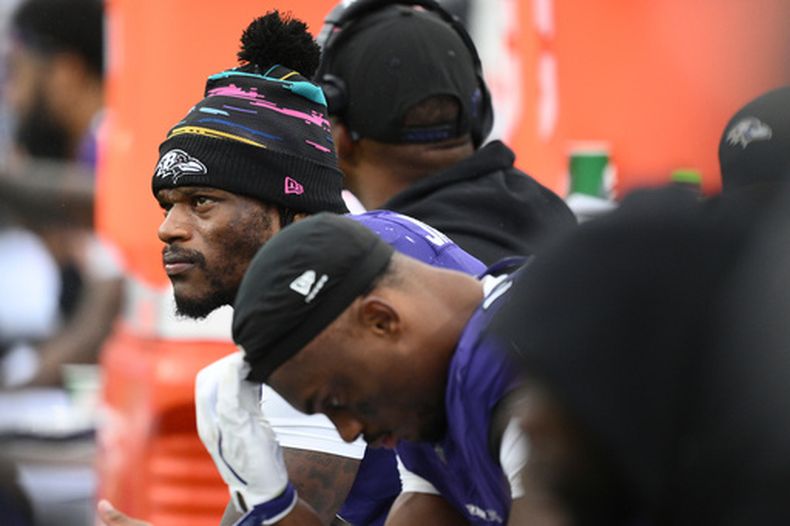 El quarterback de los Ravens de Baltimore, Lamar Jackson (izquierda), observa desde la banca durante la segunda mitad de un partido de fútbol americano de la NFL contra los Titans de Tennessee en Baltimore, el 4 de octubre de 2026. (Foto AP/Nick Wass)