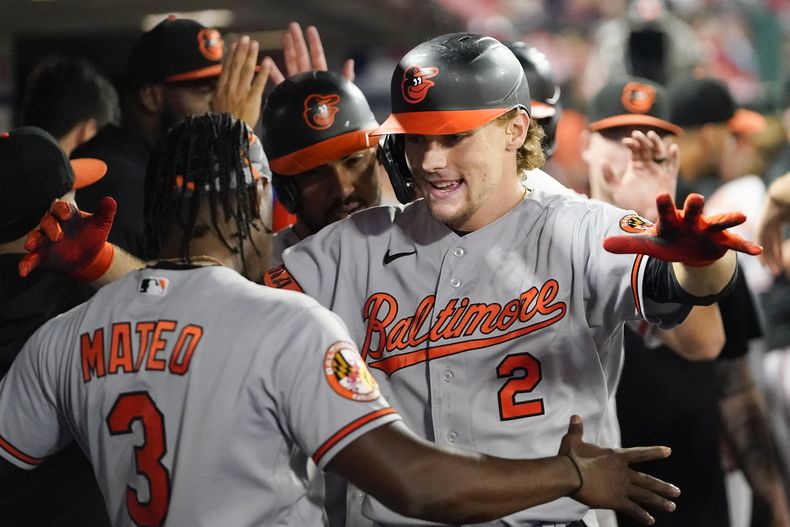 Gunnar Henderson (2) de los Orioles de Baltimore celebra junto al dominicano Jorge Mateo (3) en el banquillo luego de conectar un cuadrangular de tres carreras en la 7ma entrada del juego ante los Angelinos de Los Ángeles, en Anaheim, California. Lunes 4 de septiembre de 2023. (AP Foto/Ryan Sun)