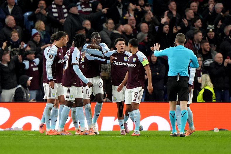 Jugadores del Aston Villa hablan con el árbitro después de que un proyectil golpeó al jugador Donyell Malen en el encuentro ante Young Boys en la Liga Europa el jueves 27 de noviembre del 2025. (Joe Giddens/PA via AP)