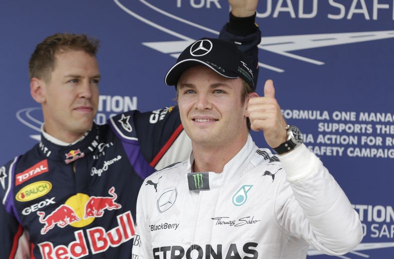 El piloto de Mercedes, Nico Rosberg, derecha, levanta el pulgar tras lograr la pole del GP de Hungr&iacute;a el s&aacute;bado, 26 de julio de 2014, en Budapest. A la izquierda, el piloto de Red Bull, Sebastian Vettel, quien largar&aacute; segundo.  (AP Ph