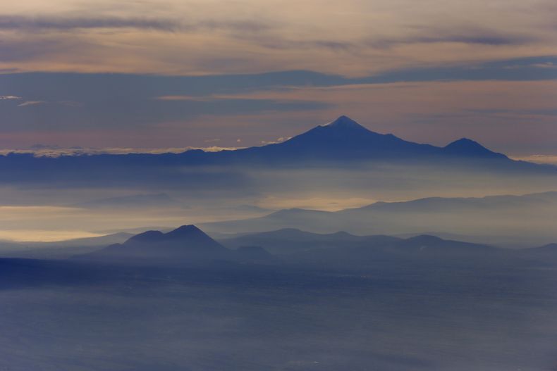 ARCHIVO - La cumbre más alta de México y la tercera de Norteamérica, Pico de Orizaba, o la montaña de Citlaltépetl, se eleva sobre la neblina de la mañana vista desde un avión de la Marina mexicana durante una misión de monitoreo de volcanes en Ciudad de México, el 23 de julio de 2013. El 21 de febrero de 2024, las autoridades informaron de la muertes de dos personas y la desaparición de varios en el Pico de Orizaba, la cumbre más alta del país. (AP Foto/Darío López-Mills, Archivo)