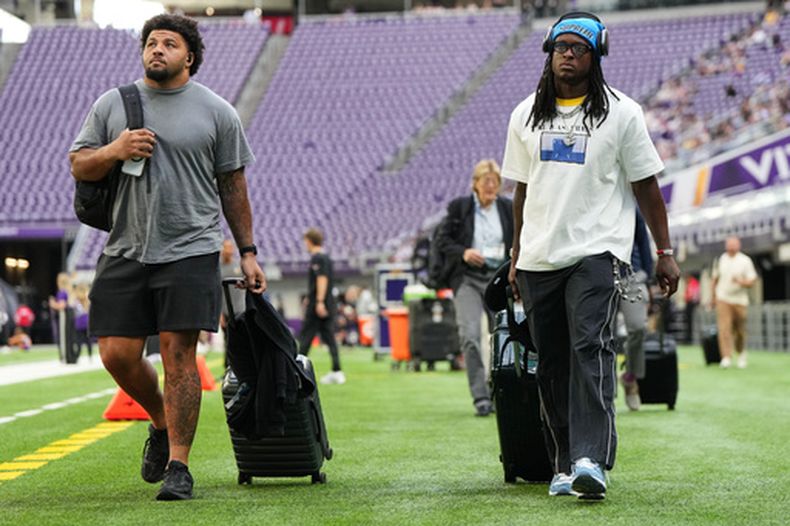 Jovaughn Gwyn, izquierda, y Kvon Wallace, de los Ravens de Baltimore, llegan al estadio previo al partido de pretemporada de la NFL en contra de los Vikings de Minnesota, el sábado 22 de agosto de 2026, en Minneapolis. (AP Foto/Abbie Parr)