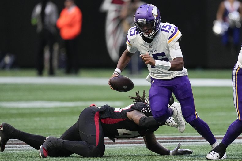 Joshua Dobbs (15), quarterback de los Vikings de Minnesota, corre para conseguir un primero y diez superando a un defensivo de los Falcons de Atlanta, durante la segunda mitad del juego de la NFL, el domingo 5 de noviembre de 2023, en Atlanta. (AP Foto/John Bazemore)