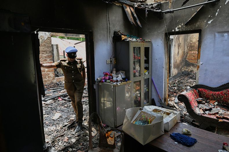 Un agente de policía de Sri Lanka inspecciona una residencia de ancianos calcinada tras un incendio ocurrido durante la noche en Anguruwatota, Sri Lanka, el jueves 4 de junio de 2026. (Foto AP)