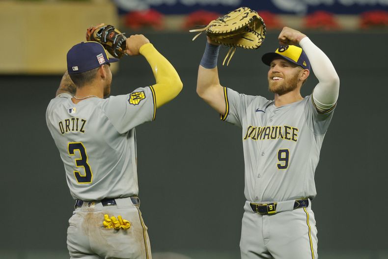 El tercera base de los Cerveceros de Milwaukee, Joseph Ortiz (3), y el primera base Jake Bauers (9), celebran después de una victoria sobre los Mellizos de Minnesota en 12 entradas, el sábado 20 de julio de 2024, en Minneapolis. (AP Foto/Bruce Kluckhohn)