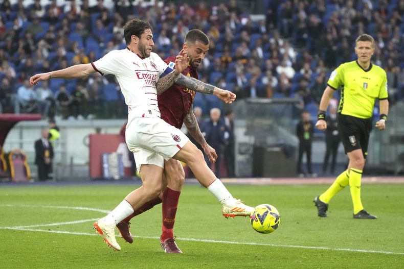 Davide Calabria del AC Milan y Leonardo Spinazzola de la Roma pelean por el balón en el encuentro de la Serie A en el Estadio Olímpico el sábado 29 de abril del 2023. (AP Foto/Gregorio Borgia)