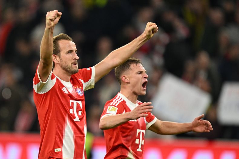 Harry Kane celebra con su compañero del Bayern Munich Joshua Kimmich la victoria ante el Borussia Dortmund en la Bundesliga el sábado 18 de octubre del 2025. (AP Foto/Lennart Preiss)