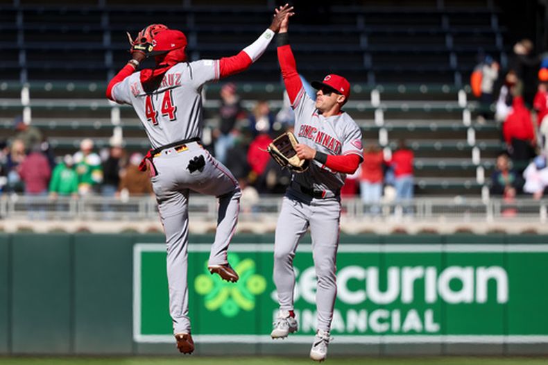 El campocorto dominicano de los Rojos de Cincinnati, Elly De La Cruz (44), y el jardinero central TJ Friedl (29) celebran la victoria ante los Mellizos de Minnesota en un partido de béisbol, el sábado 18 de abril de 2026, en Minneapolis. (AP Foto/Ellen Schmidt)