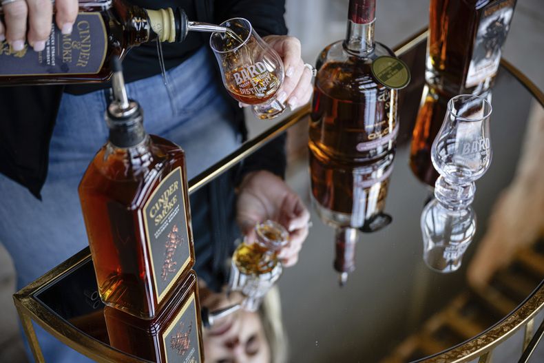 Una empleada sirve una copa del producto de The Bard en la que será una nueva área de producción en The Bard Distillery, el domingo 9 de marzo de 2025, en Graham, Kentucky. (AP Foto/Jon Cherry)