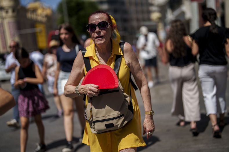 Una mujer se abanica bajo un sol abrasador en Madrid, el lunes 10 de julio de 2023. (AP Foto/Manu Fernández)