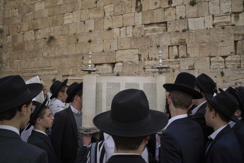 Hombres judíos ultraortodoxos participan en una bendición durante la festividad de Pascua, en el Muro Occidental, el lugar más sagrado donde los judíos pueden rezar, en la Ciudad Vieja de Jerusalén, el martes 15 de abril de 2025. (AP Foto/Leo Correa)