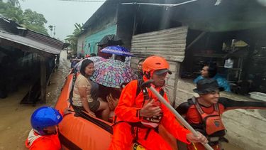 En esta imagen publicada por la Agencia Nacional de Búsqueda y Rescate de Indonesia (BASARNAS), rescatistas en un bote de goma evacúan a residentes de su hogar inundado en la provincia de Sumatra del Norte, Indonesia, el martes 25 de noviembre de 2025. (BASARNAS via AP)