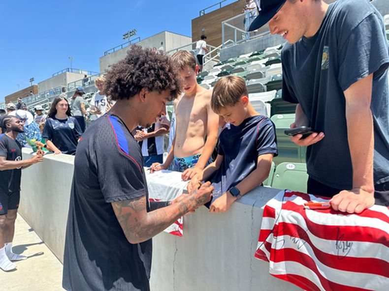 El zaguero estadounidense Chris Richards firma autógrafos tras la primera práctica de la selección en su sede en Irvine, California, el lunes 8 de junio de 2026. (AP Foto/Greg Beacham)