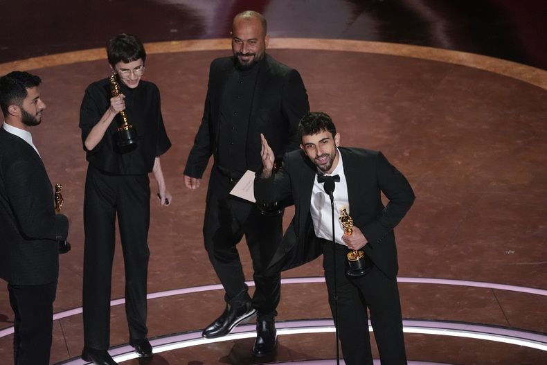 Basel Adra y de izquierda a derecha, Rachel Szor, Hamdan Ballal y Yuval Abraham aceptan el Oscar al mejor documental por No Other Land, el domingo 2 de marzo de 2025 en el Teatro Dolby de Los Ángeles. (AP Foto/Chris Pizzello)
