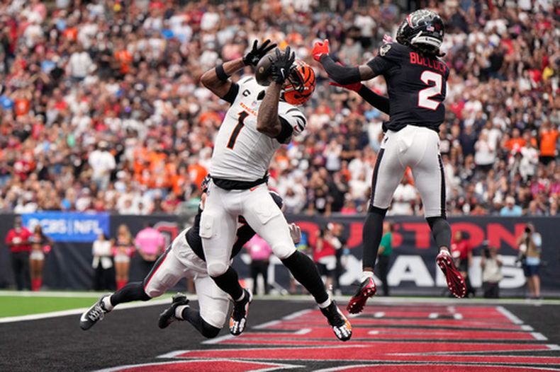 Jamarr Chase (1), receptor de los Bengals de Cincinnati, atrapa un pase para un touchdown mientras Reed Blankenship, atrás, y Calen Bullock (2), de los Texans de Houston hacen un intento por impedirlo durante la segunda mitad del partido de la NFL, el domingo 20 de septiembre de 2026, en Houston. (AP Foto/Ashley Landis)