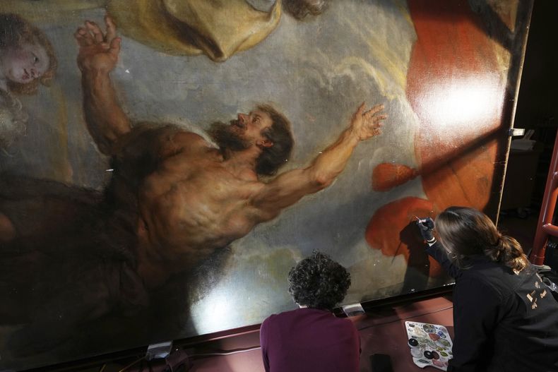 Las restauradoras de arte Jill Keppens, izquierda, y Kayla Metelenis, derecha, trabajan en secciones de Madona entronizada con niño, rodeada de santos, pintada por el artista flamenco Peter Paul Rubens, en el Museo Real de Bellas Artes de Amberes, Bélgica, el martes 28 de enero. 2025. (Foto AP/Virginia Mayo)
