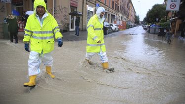 Dos personas cruzan una calle anegada en Bolonia, Italia, el 16 de mayo de 2023. (Michele Nucci/LaPresse via AP)