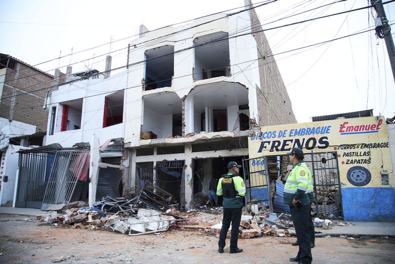 La policía permanece afuera de un edificio dañado por una explosión en Trujillo, Perú, el viernes 14 de agosto de 2025. (AP Foto/Gabriel Romero)