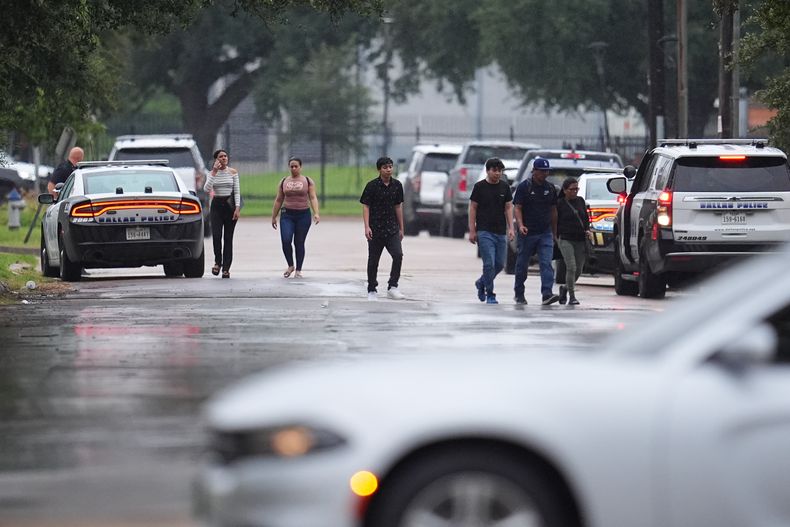 Personas que tenían citas en una oficina de inmigración en Dallas reciben órdenes de irse tras reportarse un tiroteo el 24 de septiembre del 2025. (AP foto/Julio Cortez)