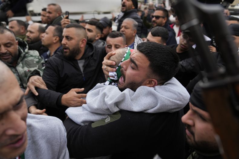 Una multitud recibe a varios presos palestinos que bajan de un autobús de la Cruz Roja tras ser liberados de una prisión israelí en un cese al fuego entre Israel y Hamás, en la ciudad cisjordana de Ramala, el sábado 1 de febrero de 2025. (AP Foto/Nasser Nasser)