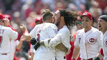 Nick Senzel (centro izquierda) celebra con Jonathan India tras batear el jonrón para la victoria ante los Rangers de Texas, el miércoles 26 de abril de 2023, en Cincinnati. (AP Foto/Jeff Dean)