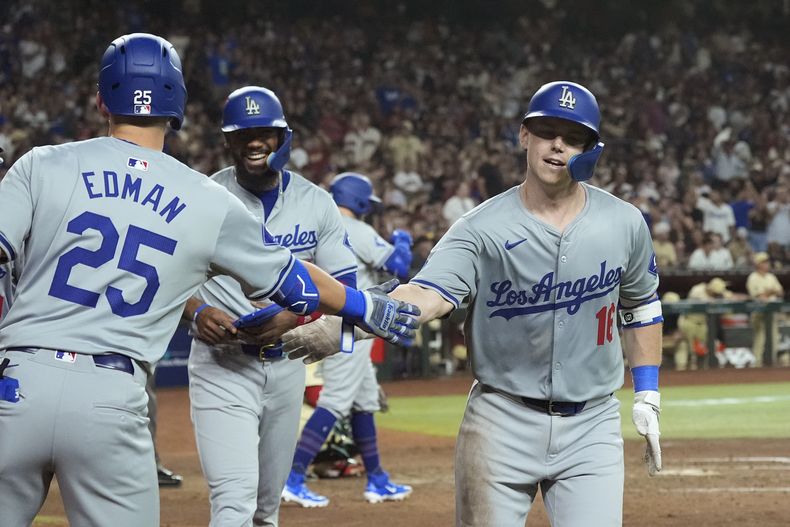 Will Smith (derecha), de los Dodgers de Los Ángeles, festeja su jonrón de tres carreras en el duelo del viernes 30 de agosto de 2024, ante los Diamondbacks de Arizona (AP foto/Ross D. Franklin)