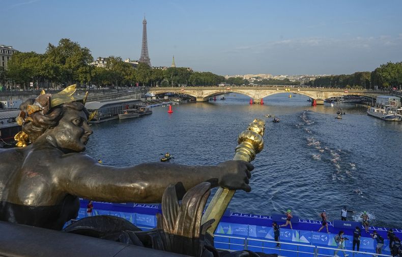 ARCHIVO - Triatletas compiten en el río Sena durante una prueba femenina previo a los Juegos Olímpicos de París, el 17 de agosto de 2023. (AP Foto/Michel Euler)