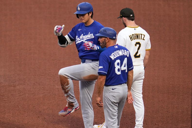 Shohei Ohtani, de los Dodgers de Los Ángeles (izquierda), celebra mientras está parado en la primera base tras conectar un sencillo ante el lanzador de los Piratas de Pittsburgh, Mitch Keller, durante la cuarta entrada de un partido de béisbol en Pittsburgh, el jueves 11 de junio de 2026. (Foto AP/Gene J. Puskar)