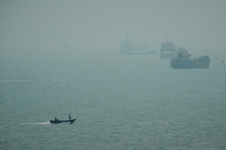 Un bote de motor pasa junto a embarcaciones mercantes en medio de la bruma en el estrecho de Ormuz, cerca de Bandar Abbas, Irán, el lunes 7 de septiembre de 2026. (AP Foto/Vahid Salemi)