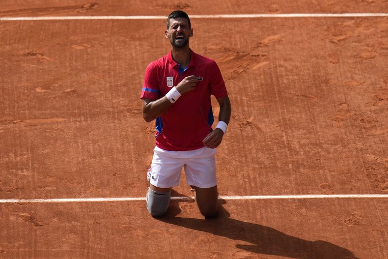 El serbio Novak Djokovic reacciona tras derrotar al español Carlos Alcaraz en la final de tenis individual masculino en el estadio de Roland Garros durante los Juegos Olímpicos de Verano de 2024, el domingo 4 de agosto de 2024, en París, Francia. (AP Foto/Andy Wong)