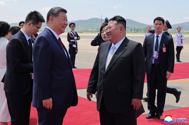 En esta imagen proporcionada por el gobierno norcoreano, el líder norcoreano, Kim Jong Un, delante a la derecha, recibe al presidente de China, Xi Jinping, a la izquierda, a su llegada al aeropuerto de Pyongyang, el lunes 8 de junio de 2026. Periodistas independientes no tuvieron acceso a la cobertura del evento mostrado en esta imagen distribuida por el gobierno norcoreano. La imagen está tal y como se recibió y no pudo verificarse de forma independiente. La marca de agua fue incluida por la fuente y dice ACNC, la abreviatura de la Agencia Central de Noticias de Corea. (Agencia Central de Noticias de Corea/Korea News Service vía AP)