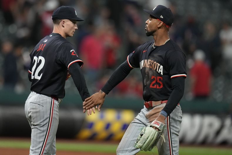 El lanzador de los Mellizos de Minnesota, Griffin Jax, a la izquierda, y el jardinero central Byron Buxton celebran después de que los Mellizos derrotaron a los Guardianes de Cleveland el martes 17 de septiembre de 2024, en Cleveland. (AP Foto/Sue Ogrocki)